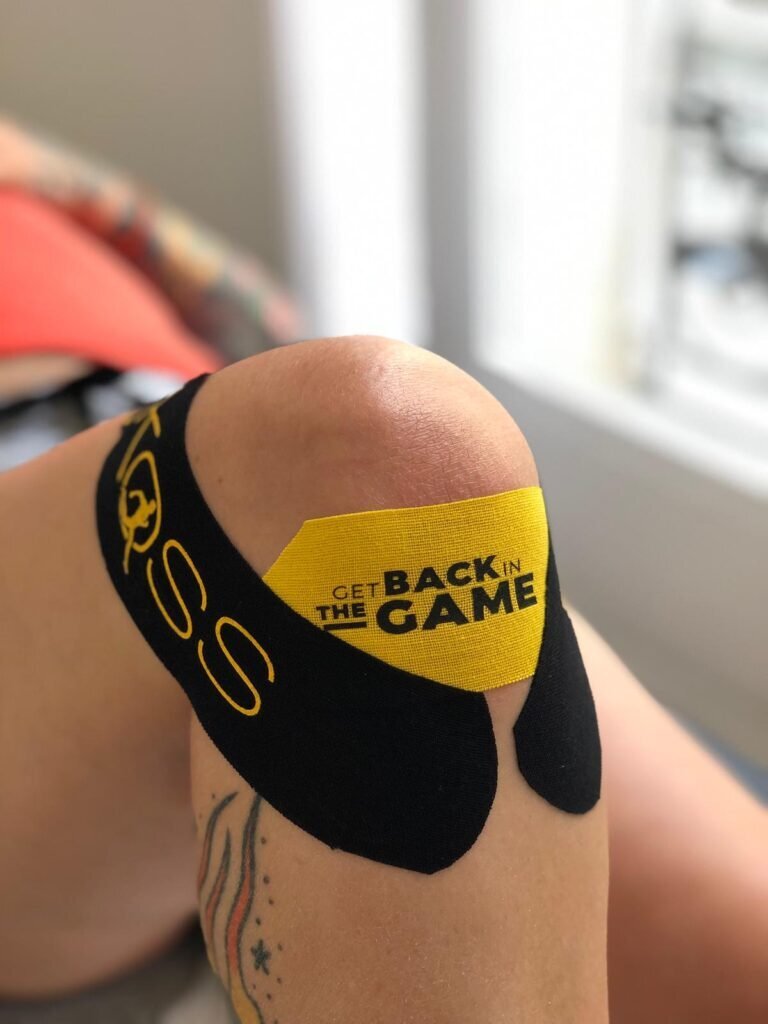 Genou d&rsquo;un sportif avec taping appliqu&eacute; dans le cadre d&rsquo;une prise en charge en kin&eacute;sith&eacute;rapie du sport