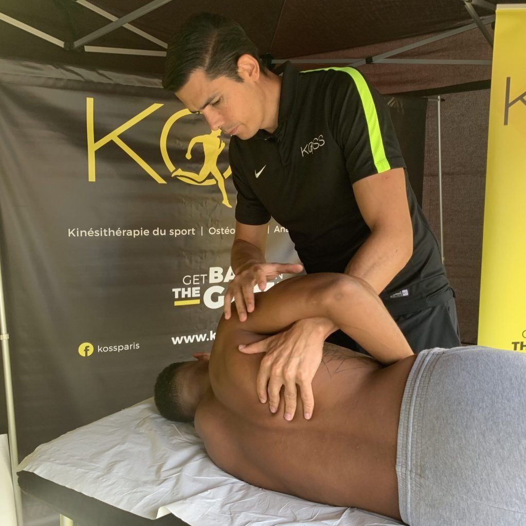 S&eacute;ance de th&eacute;rapie manuelle r&eacute;alis&eacute;e par un kin&eacute;sith&eacute;rapeute du sport sur un athl&egrave;te allong&eacute;