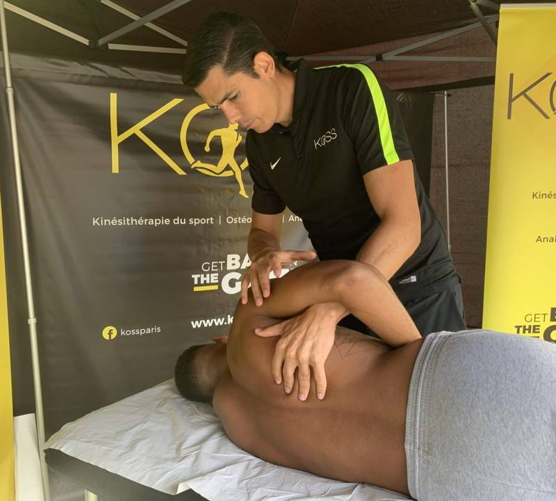 S&eacute;ance de th&eacute;rapie manuelle r&eacute;alis&eacute;e par un kin&eacute;sith&eacute;rapeute du sport sur un athl&egrave;te allong&eacute;